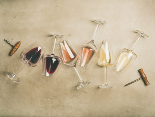 Witte, rode en rosé wijn in glazen liggend met kurkentrekkers